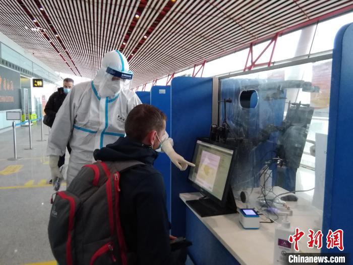  图为北京海关所属首都机场海关关员帮助参加测试赛的入境人员进行申报。　北京海关供图 摄影 卢孟晓