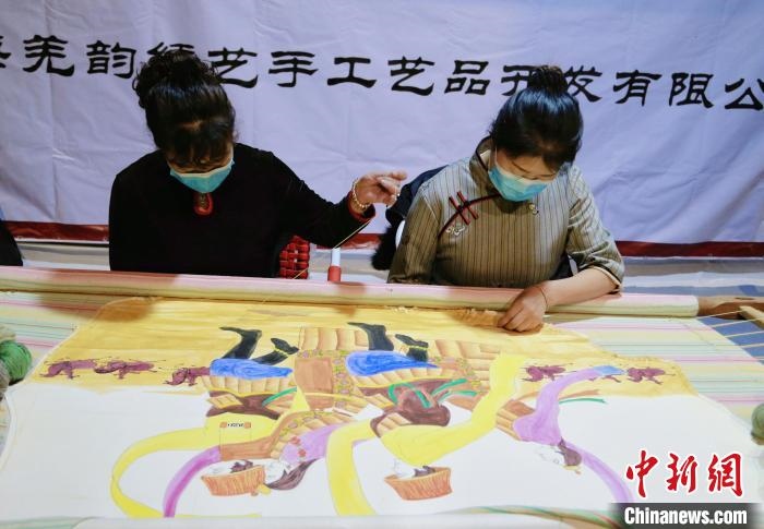 图为皮绣艺人在市集上“秀”指尖技艺。　马铭言 摄