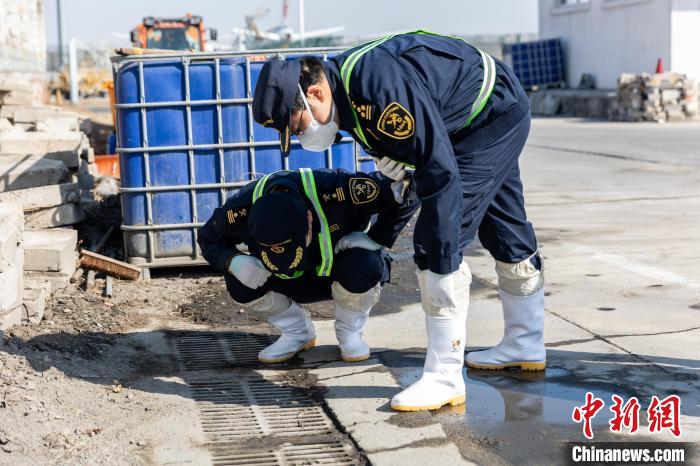 首都机场海关关员在污水倾倒口附近进行病媒生物孳生地排查。　方星 摄