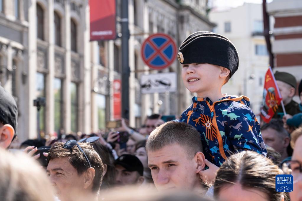 5月9日，人们在俄罗斯符拉迪沃斯托克市观看阅兵式。新华社发（郭飞洲摄）