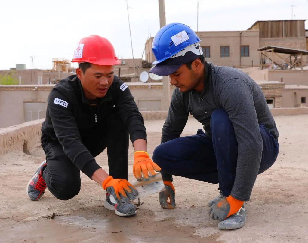 在乌兹别克斯坦希瓦古城，中方文物修复人员在指导乌方工作人员进行修复工作。