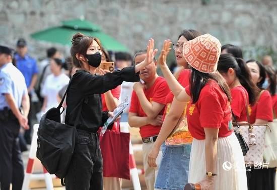 6月7日，北京市第九中学考点，考生与送考家长击掌加油。人民网记者 于凯摄