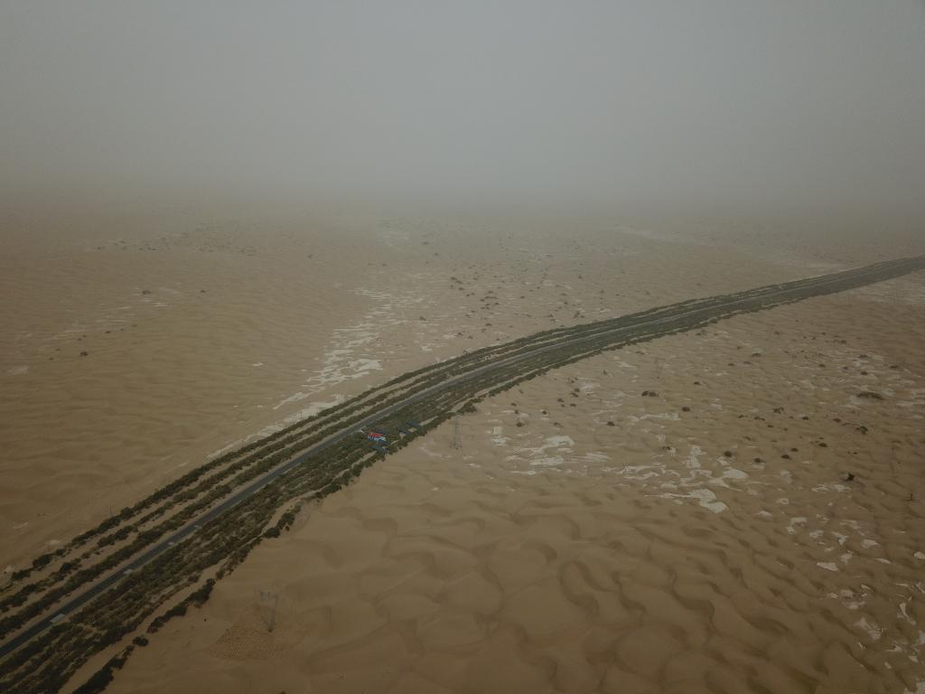 这是2019年8月12日拍摄的塔里木沙漠公路两侧的绿色屏障（无人机照片）。新华社记者宿传义摄