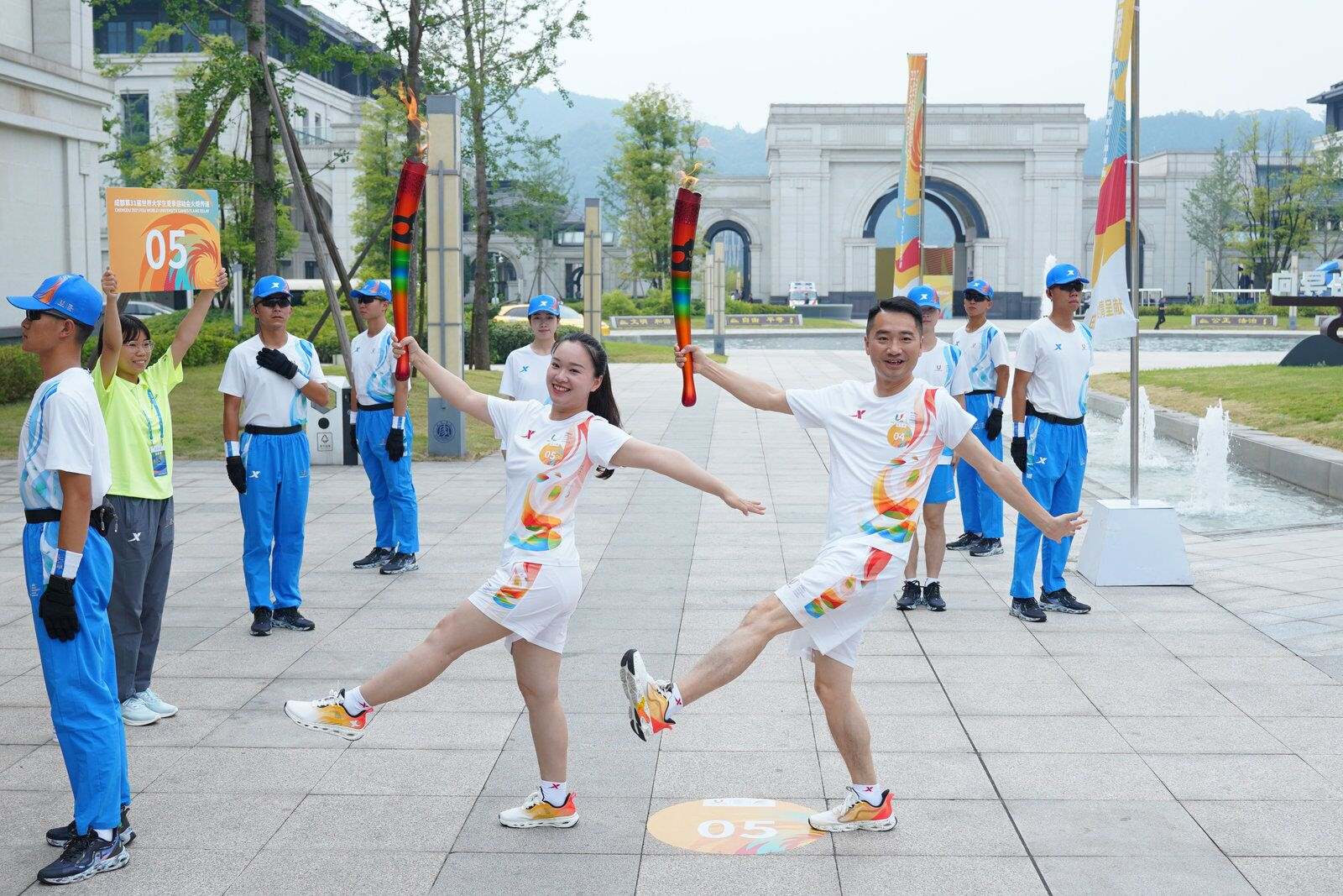 两位火炬手完成火炬传递。 图片来源：成都大运会执委会