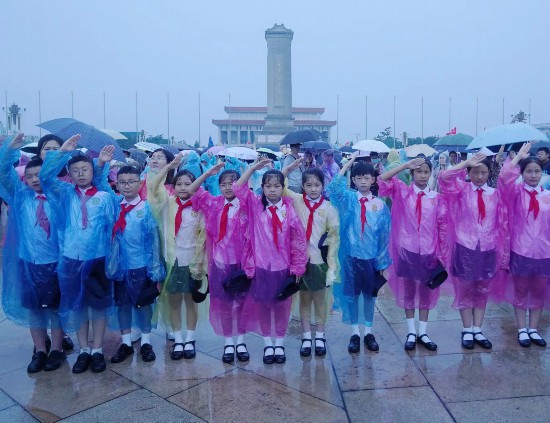 文县东童声合唱团的孩子们面向冉冉升起的国旗敬队礼。