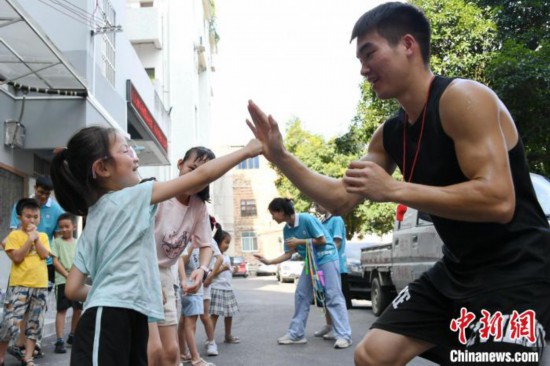 图为大学生志愿者在组织孩子们参加体育健身活动。廖光福 摄