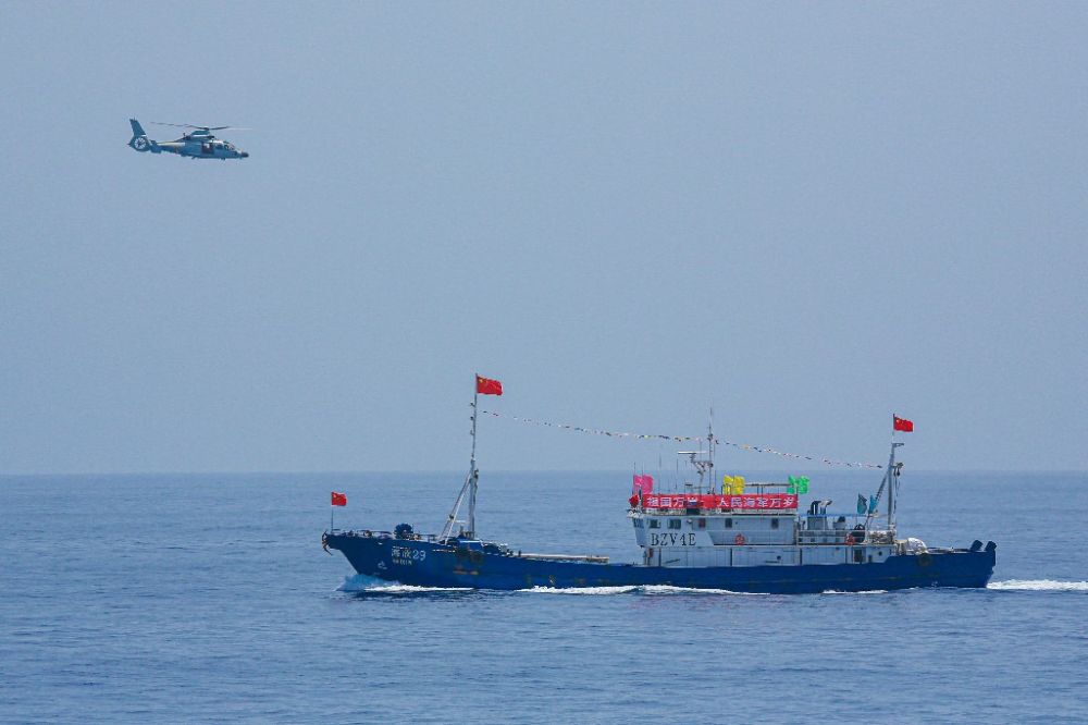 ↑中国海军第40批护航编队中的舰载直升机在被护船只周边海域巡逻警戒（2022年6月4日摄）。新华社发（唐文 摄）