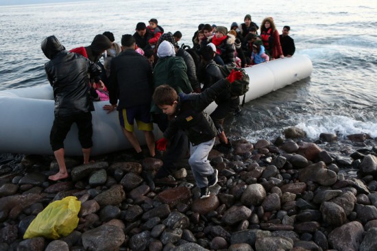  2020年3月2日，在希腊莱斯沃斯岛，难民和非法移民从一艘经土耳其由海路进入希腊境内的船上下来。新华社发（马里奥斯·罗洛斯摄）