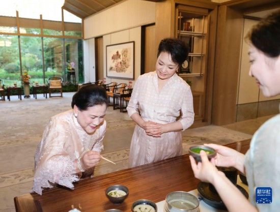 7月27日下午，国家主席习近平夫人彭丽媛在四川成都会见陪同印度尼西亚总统佐科来华出席第31届世界大学生夏季运动会开幕式并访华的总统夫人伊莉亚娜。这是彭丽媛邀请伊莉亚娜观看茶艺表演，并同伊莉亚娜亲切茶叙。新华社记者 丁林 摄