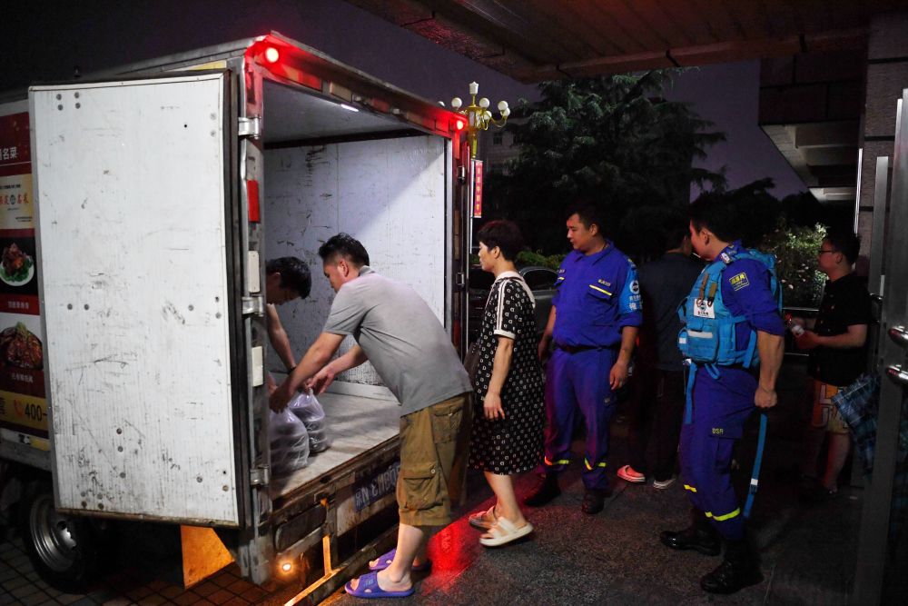 河北省涿州市职教中心安置点的工作人员在运送饭菜，准备发放给安置群众（8月1日摄）。新华社记者 牟宇 摄