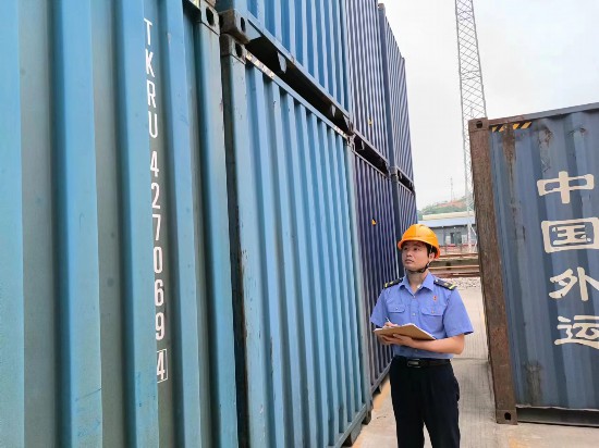 铁路货运员在检查集装箱箱体情况、记录箱号。中国铁路广州局集团有限公司供图