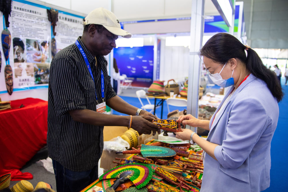  参展商（左）在第三届中国-非洲经贸博览会展会上向观众介绍产品（6月29日摄）。新华社记者 陈思汗 摄