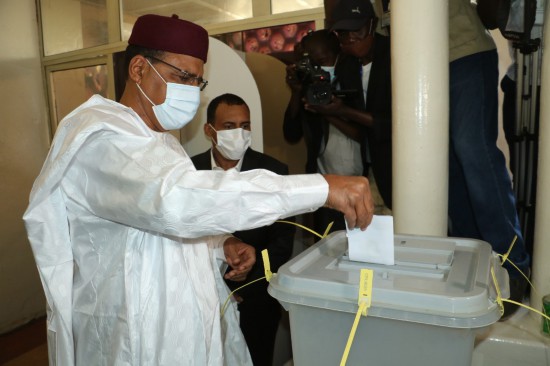  2021年2月21日，尼日尔争取民主和社会主义党候选人穆罕默德·巴祖姆（前）在尼亚美的一处投票站投票。新华社发