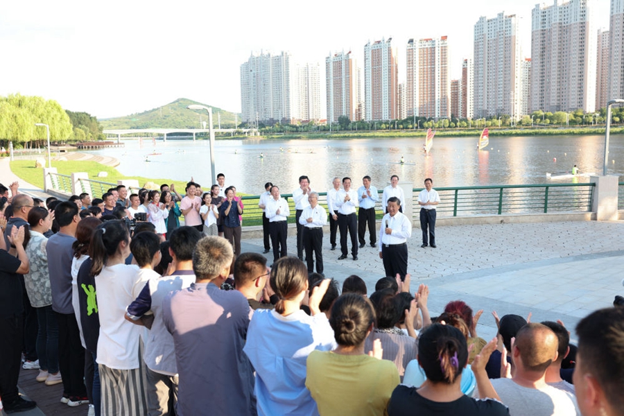 2022年8月16日，习近平在辽宁锦州东湖森林公园察看小凌河沿岸生态环境时，同正在休闲、进行文化活动的群众亲切交流。