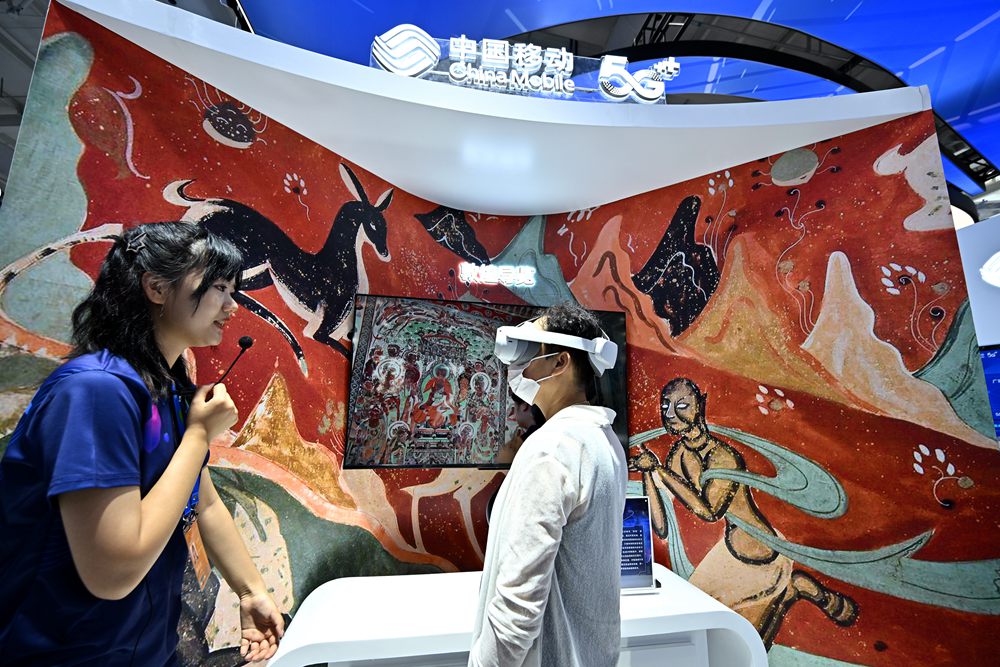 9月3日，一名参观者在首钢园中国移动展台体验基于AR/VR特效的敦煌导览，沉浸式感受敦煌壁画的魅力。新华社记者 李鑫 摄