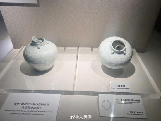 福建德化窑白釉印花四系罐（左）。人民网记者 李娜摄