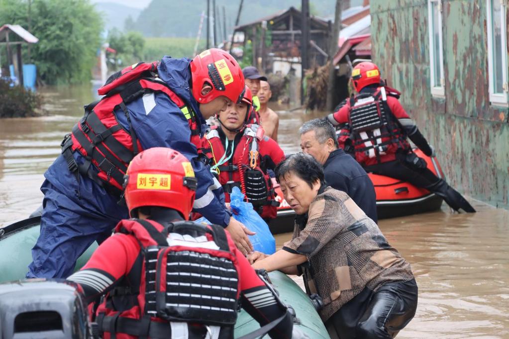 8月4日，在黑龙江省尚志市一面坡镇万山村，哈尔滨市森林消防支队的消防员在解救被困村民。新华社发