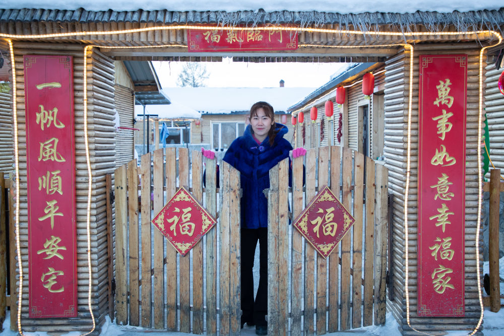 北极村民宿经营者史瑞娟在门前迎候入住的游客（2023年1月7日摄）。
