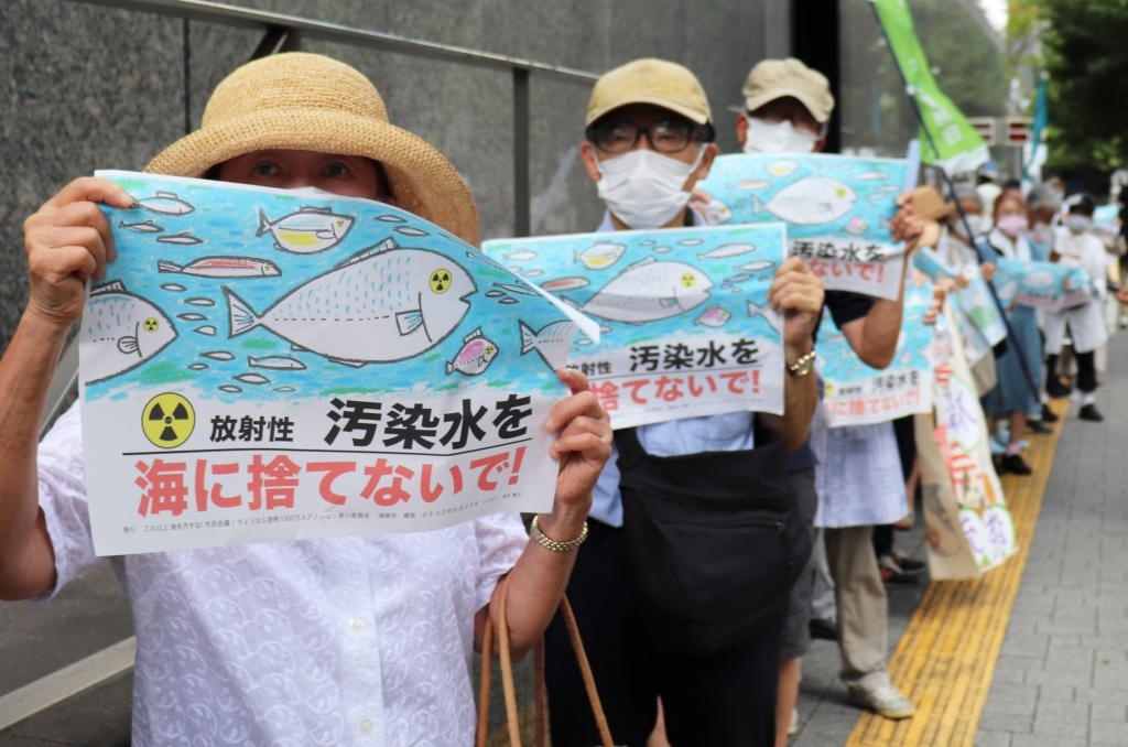 8月24日，日本民众手持“不要将污染水扔进大海”等标语在东京电力公司总部前集会，抗议日本政府和东电公司无视民意启动核污染水排海。新华社记者杨光摄