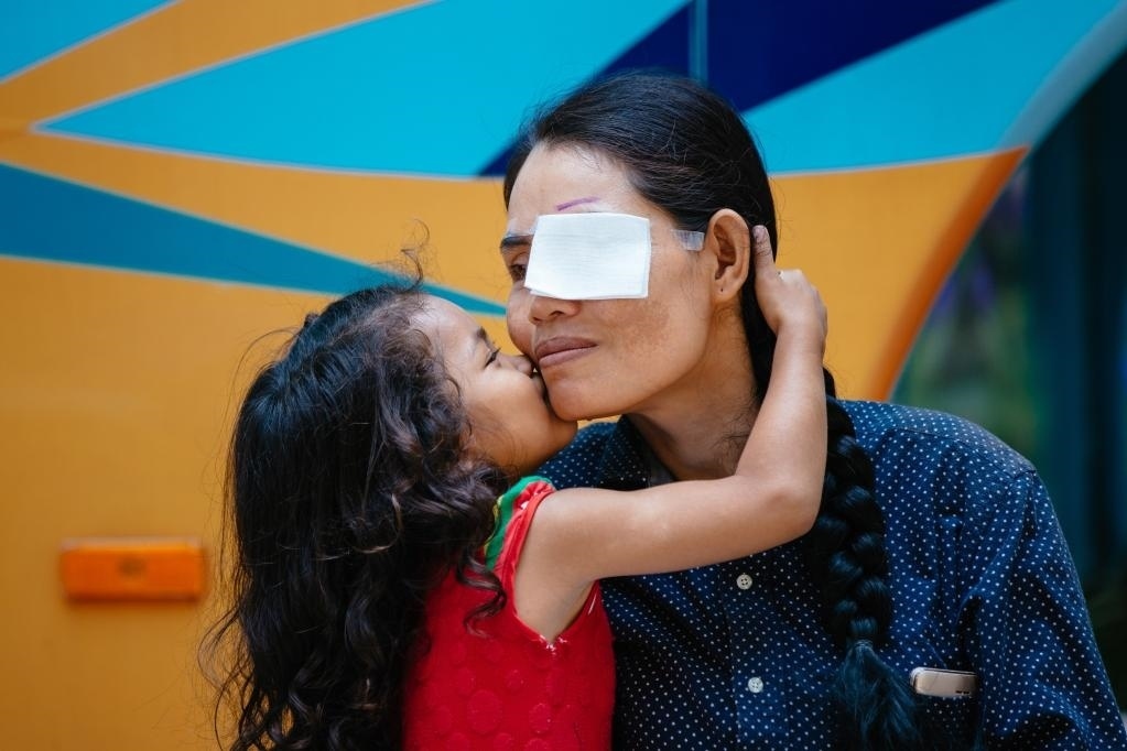 2019年3月15日,在柬埔寨磅湛省医院,即将接受白内障手术的患者孙美乐接受女儿的亲吻祝福。在接受了中国医疗队的白内障义诊手术后,她的视力逐步恢复,生活有了新的光明和希望。