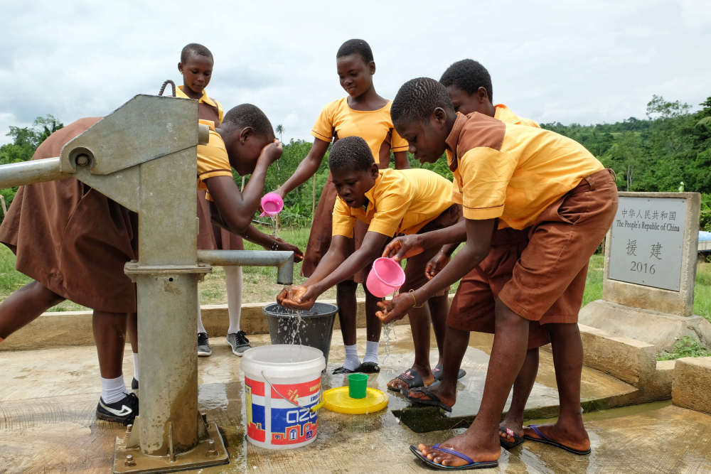 2018年6月18日，在加纳东部省古阿由兹村，当地学生从中国援建的水井中打水。新华社记者 赵姝婷 摄
