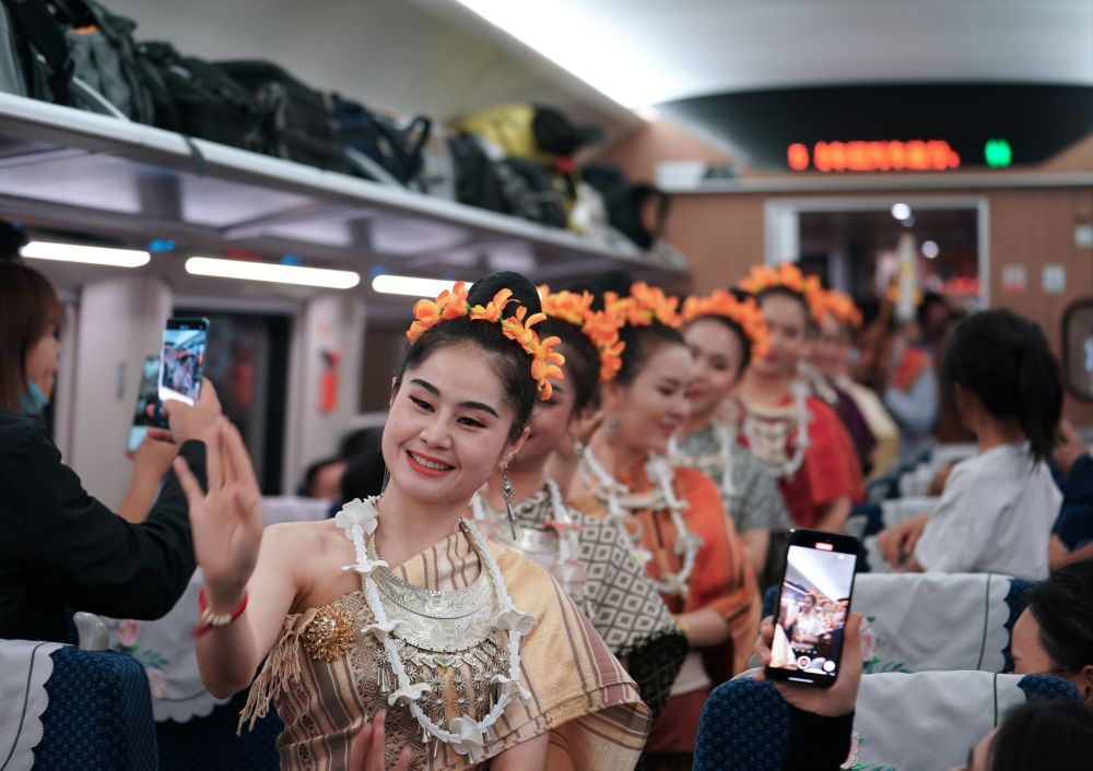 2023年4月13日，老挝工作人员在中老铁路上开行的D887次国际旅客列车上表演。新华社记者 邢广利 摄