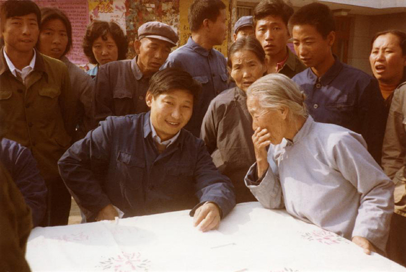1983年，时任河北正定县委书记的习近平（前排居中）临时在大街上摆桌子听取老百姓意见。