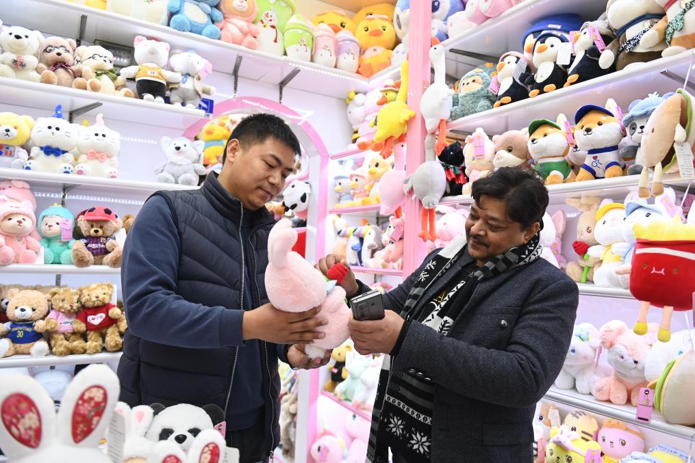 2023年2月2日，来自印度的客商（右）在义乌国际商贸城的一家玩具店铺内选购商品。新华社记者 黄宗治 摄