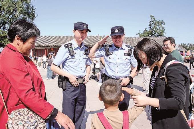 青龙桥派出所民警与游客互动。赵达摄