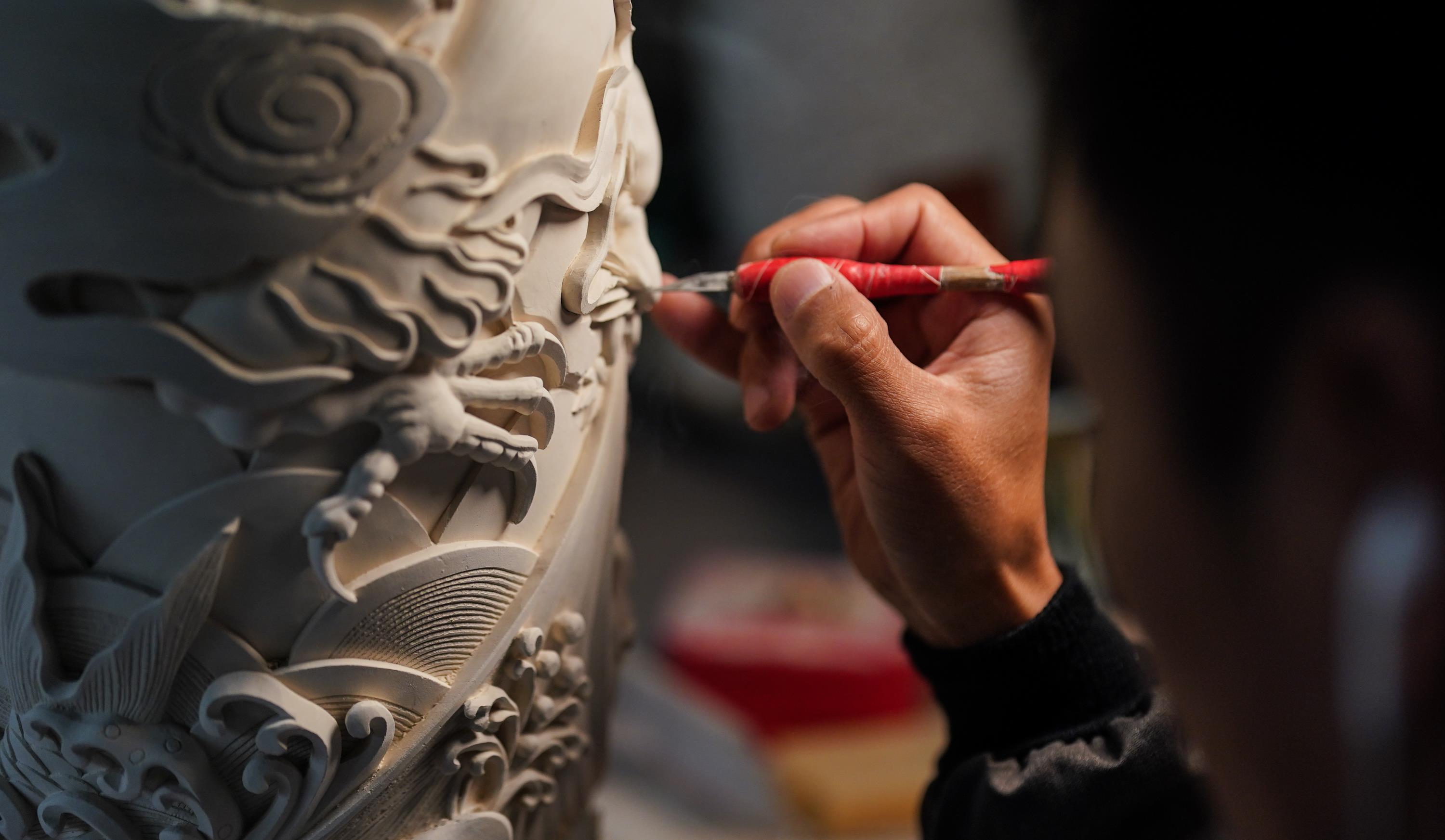 △景德镇工匠在进行陶瓷雕刻。（总台国广记者李晋拍摄）