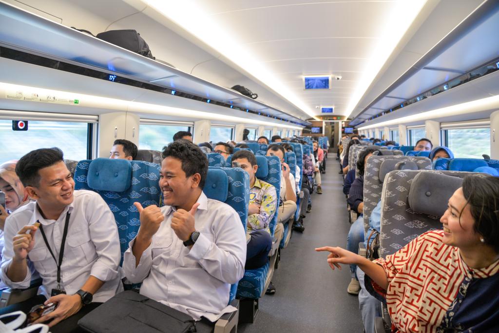 10月17日，乘客在行驶中的雅万高铁高速动车组列车车厢内交谈。