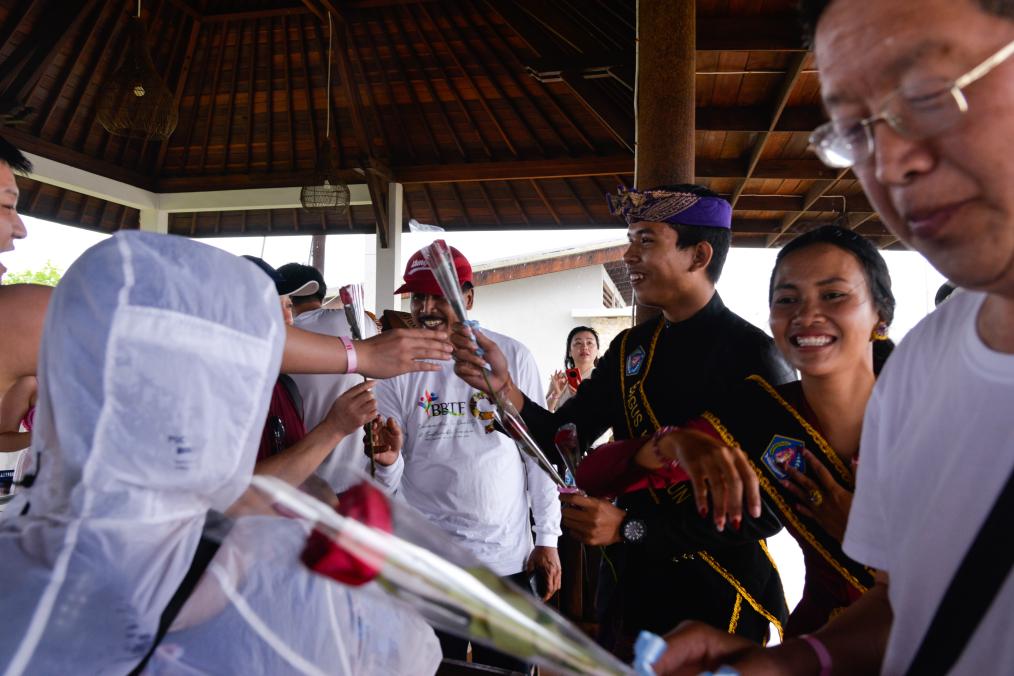2月14日，在印度尼西亚巴厘省伦邦岸岛，当地旅游业工作人员为中国游客送上鲜花。