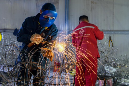 焊工在自贡市大安区某彩灯制作厂赶制彩灯。新华社记者唐文豪 摄