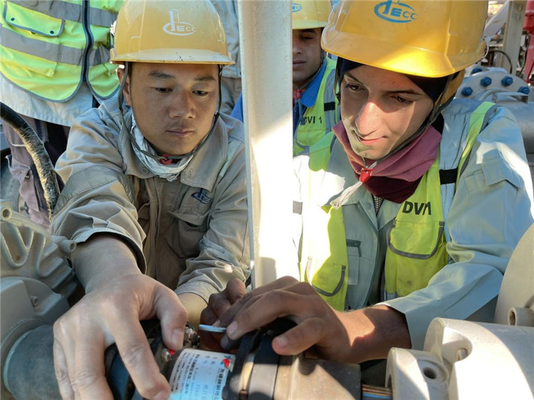 图为常遥（左）和他的徒弟舍拉勒。中国石油工程建设有限公司供图