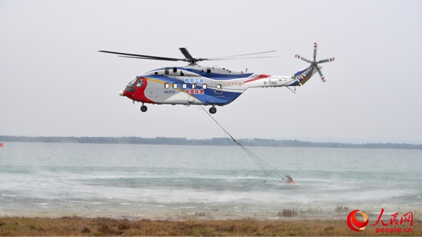 图为AC313消防直升机正在使用吊桶取水。人民网记者 唐宋摄