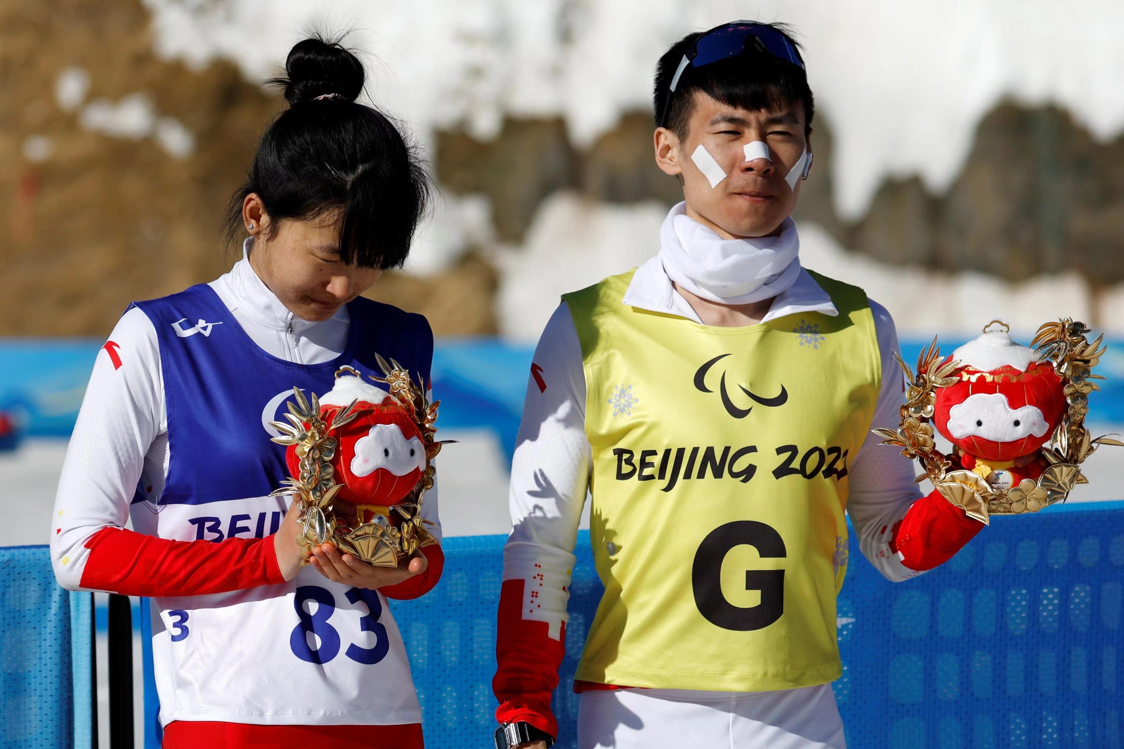 △2022年3月8日，在2022冬残奥会残奥冬季两项女子中距离（视障）比赛中，中国选手王跃（左）获季军。