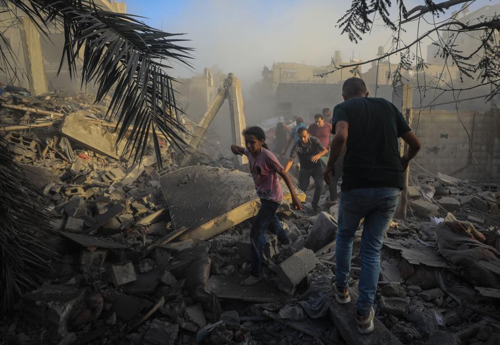 11月6日，人们从加沙地带中部地区一处被炸难民营逃离。新华社发（亚西尔·库迪摄）