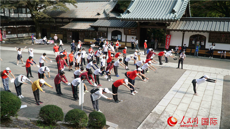 开跑前，中日青少年一起做热身运动。人民网 蒋晓辰摄