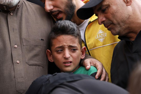 11月12日，一名男孩在加沙地带南部城市汗尤尼斯悼念逝者。新华社发（里泽克·阿卜杜勒贾瓦德摄）