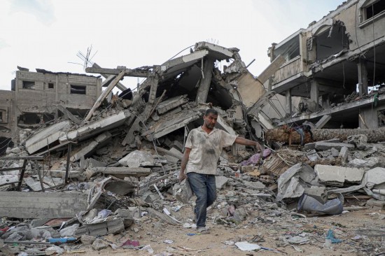 11月12日，一名男子在加沙地带南部城市汗尤尼斯清理建筑废墟。新华社发（里泽克·阿卜杜勒贾瓦德摄）