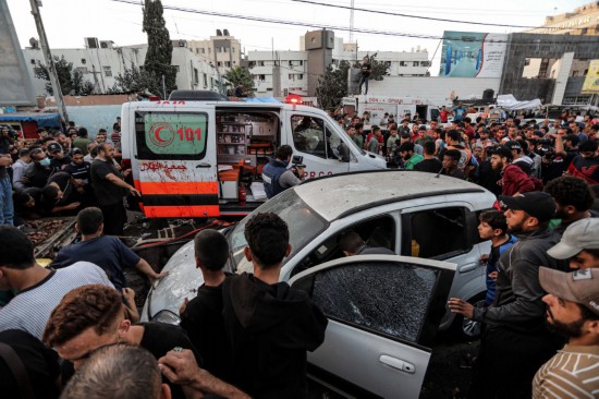 11月3日，在加沙城希法医院门口，人们查看被袭击的车辆。新华社发