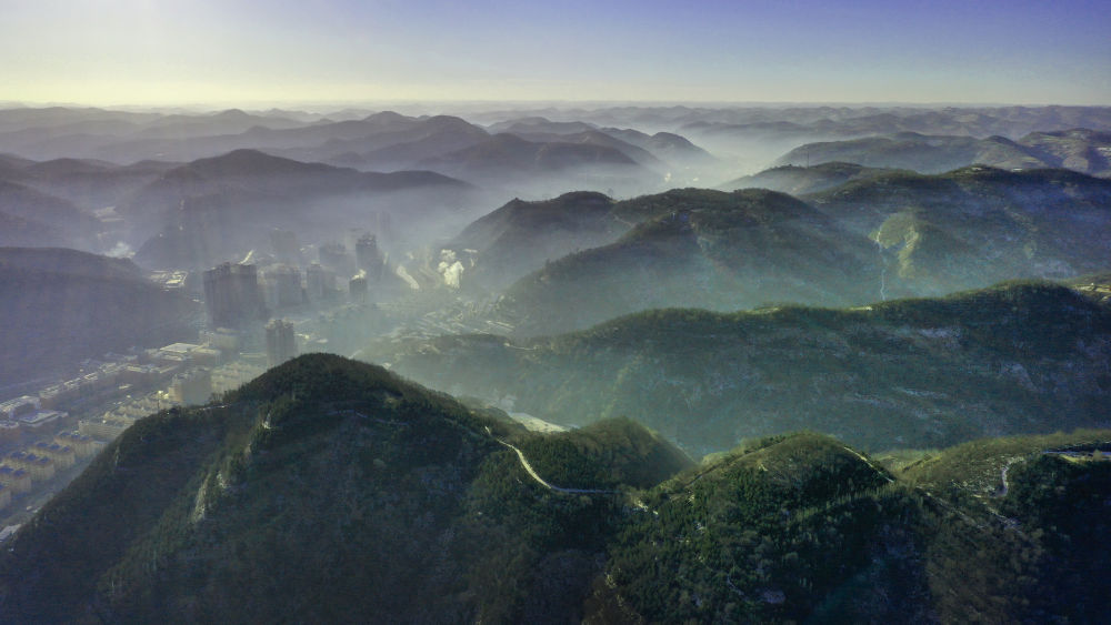 陕西省延安市吴起县的山山峁峁被茂密的山林覆盖（2021年12月20日摄，无人机照片）。新华社记者 陶明 摄