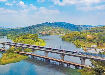 雅万高铁一列动车组从爪哇省普瓦加达县一座大桥上驶过。