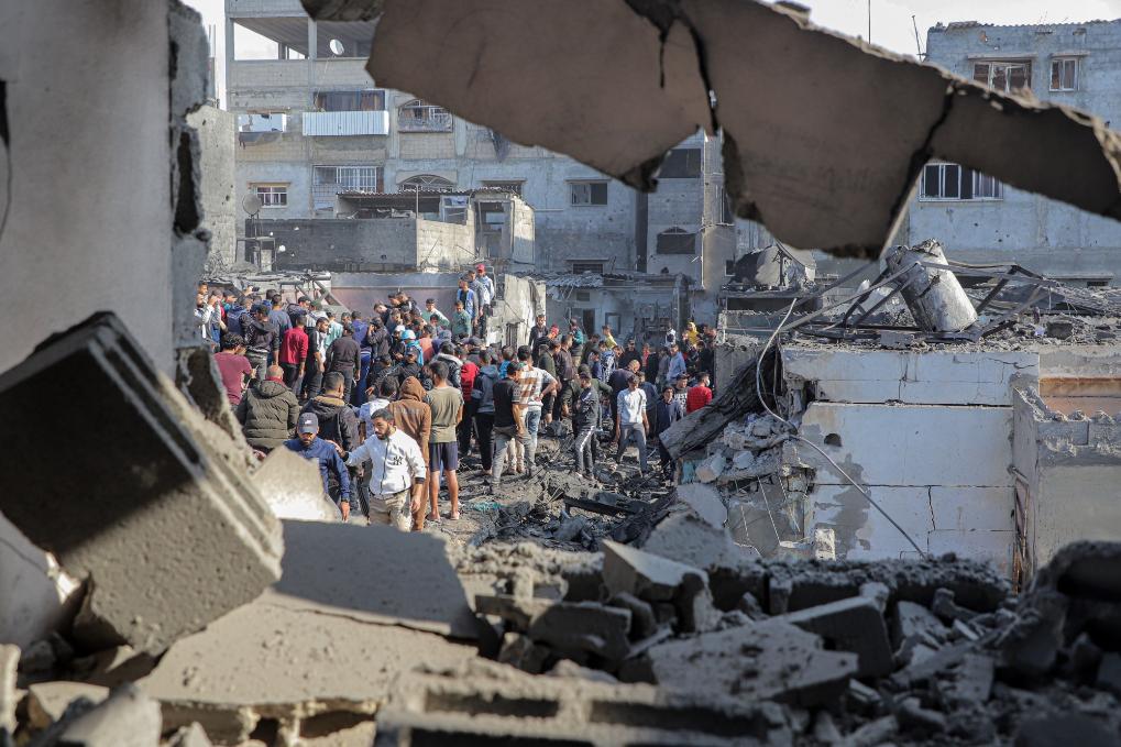 12月1日，在加沙地带南部城市汗尤尼斯，人们查看以军空袭后的废墟。新华社发（里泽克·阿卜杜勒贾瓦德摄）