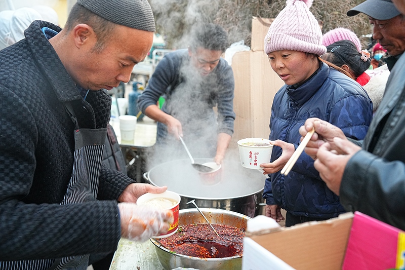 临时安置点外，拉面的香气四溢。贺勇摄。