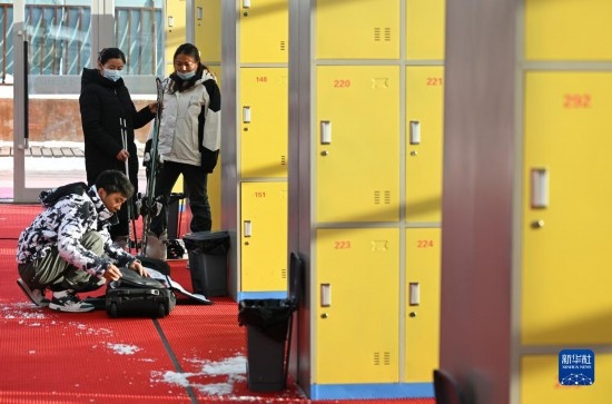 12月21日,游客在滑雪服务大厅整理滑雪装备。