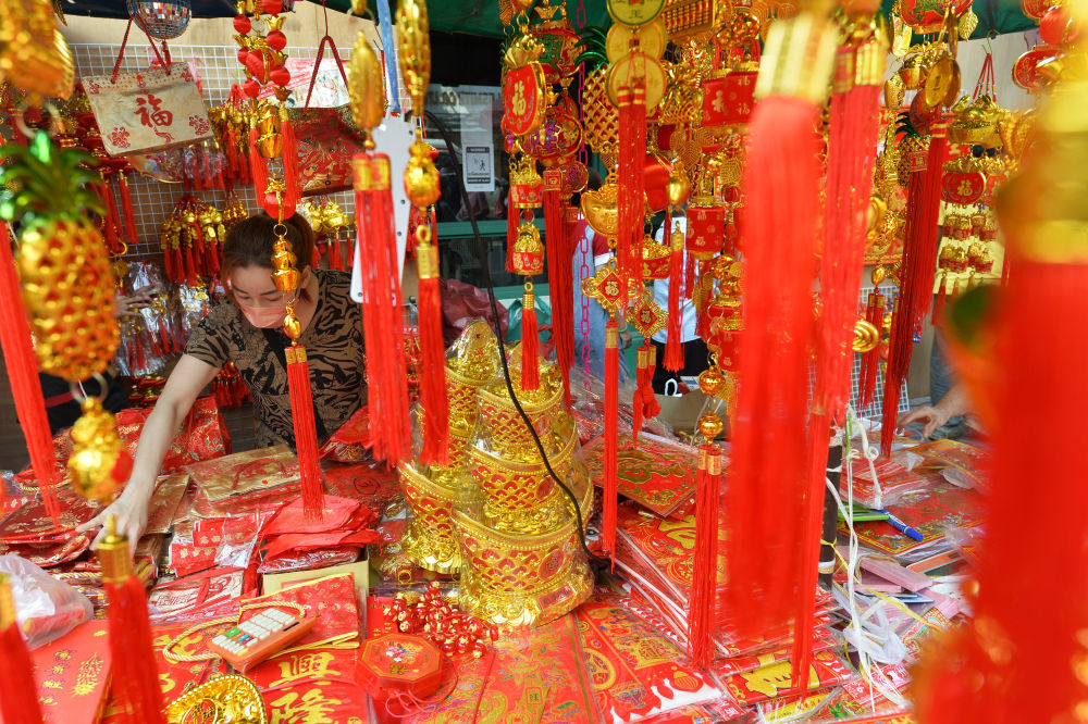 一名商贩在泰国曼谷唐人街的摊位上摆放春节饰品。新华社发（拉亨摄）