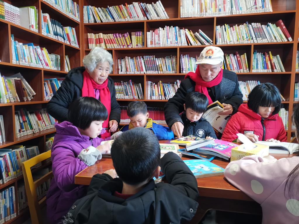 夏昭炎夫妇在谭家垅村的小书屋辅导小学生。（刘峰 摄）