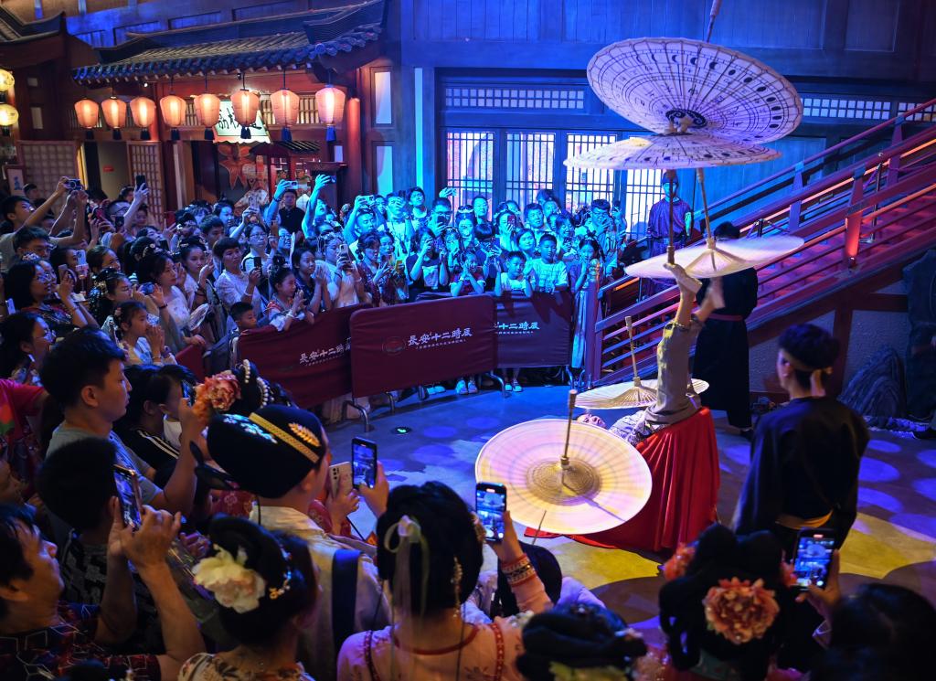 游客在长安十二时辰主题街区观看唐风演艺《长安百艺》。新华社记者邹竞一 摄