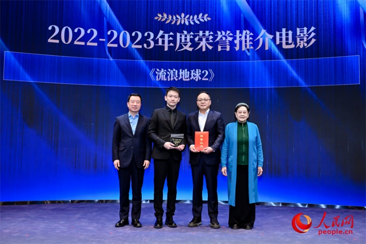 著名电影艺术家、事业家王晓棠（右一）和中国文联书记处书记张宏（左一）为《流浪地球2》出品人、总监制、总制片人傅若清（右二）与导演郭帆（左二）颁发“2022-2023年度荣誉推介电影”